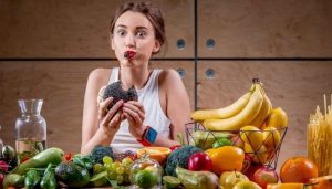 Питание, продукты красивые овощи и фрукты кушает девушка
