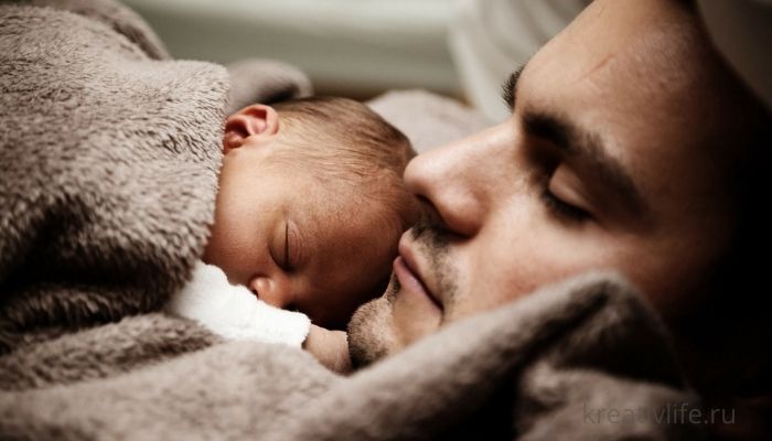Отец спит с новорожденным ребенком