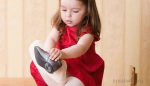 Самостоятельная девочка ребенок одевает обувь