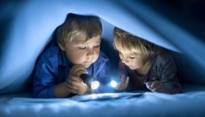 Дети с фонариком читают книгу