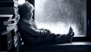 Грустный ребенок сам сидит у окна