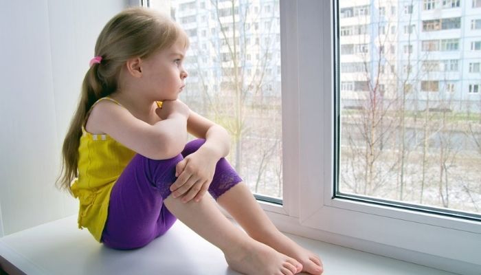 Девочка дома сама сидит на окне
