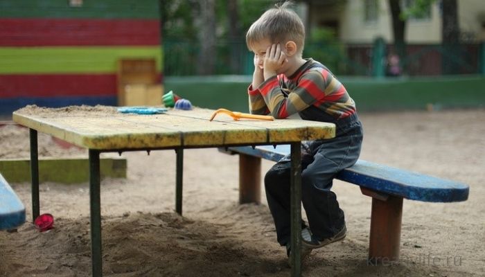 Ребенок один на детской площадке грустный 