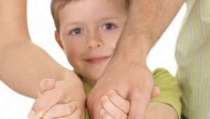 ребенок держит за руку родителей