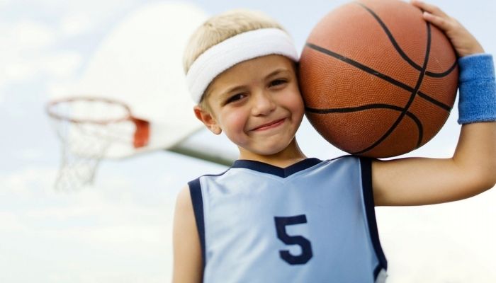 Мальчик занимается спортом играет в баскетбол