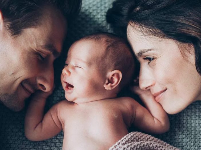 новорожденный маленький ребенок и молодые родители