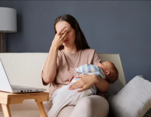 Молодая уставшая мама с младенцем на руках